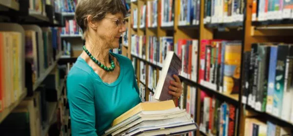 Librarian Peers Out From Behind Large Pile Of Books