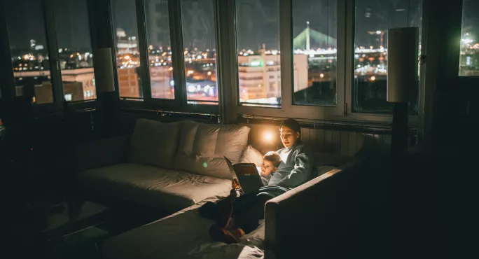 Parent Reading To Child, In The Living Room Of A Large Flat