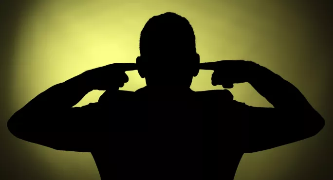 Silhouette Of Man, With His Fingers In His Ears