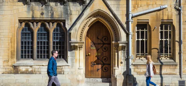 A Couple Of Students Walk Past The Door Of An Oxford College
