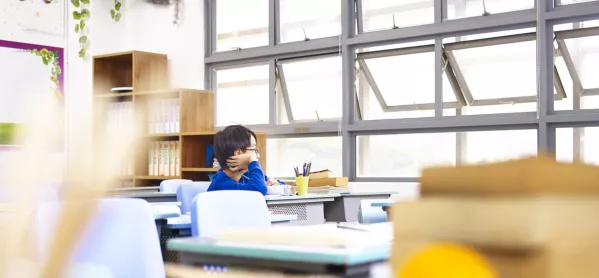 Boy Sitting Alone In Classroom, By Row Of Open Windows
