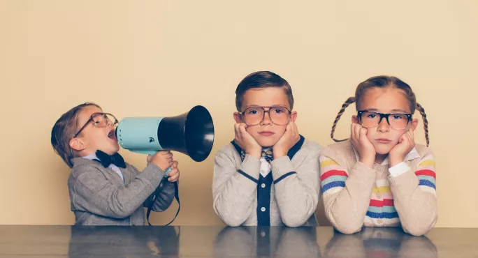 T Levels: A Small Boy Shouting Through A Megaphone At Two Girls With Hands Over Their Ears