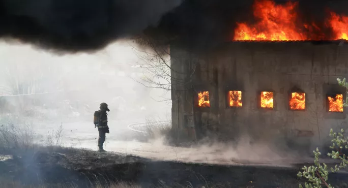 Man, Standing Next To Burning Building