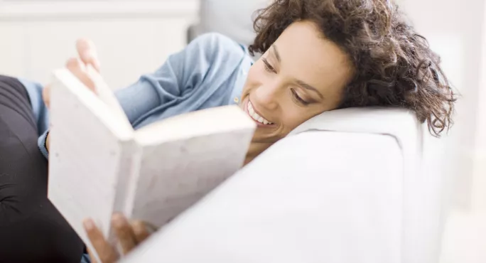 Woman Lies On The Sofa, Reading A Book