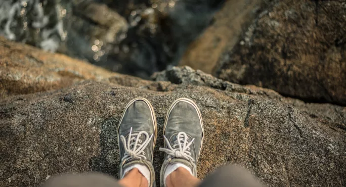 Pair Of Feet Stand On A Cliff Edge