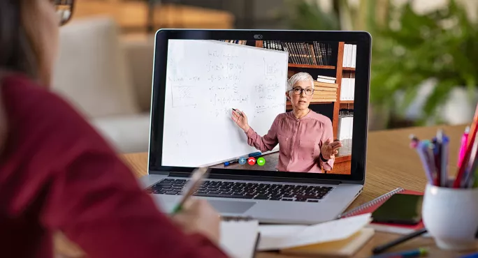 A Student Watching A Video Lesson On A Laptop Screen