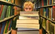 A-level exam dates 2024 – A-level student in library with stack of books