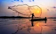man on boat casting net