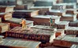 Plastic toy children running up steps of books