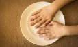 Empty plate with child's hands