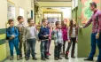 Teacher welcoming pupils to class