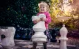 Small girl playing with life sized chess pieces