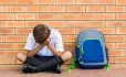 Pupil sitting against a wall