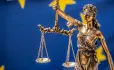 Scales of justice with Euro flag in background