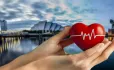 Hands holding heart with backdrop of Glasgow