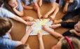 School children pointing at a world map