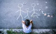 Child looking at chalk drawing of a family