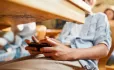 Student looking at mobile phone under desk