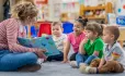 Young children reading with a teacher