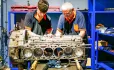 Two men fixing an engine