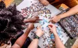 Several hands putting together puzzle pieces