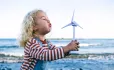 Small child blowing on windmill Sustainability Scotland