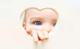 Baby looking through heart shape