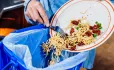 Scraping food into bin