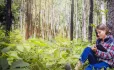 Girl writing in a forest