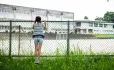 Girl at school fence
