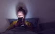Young girl in bed on phone