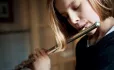 Girl playing flute in a music lesson