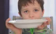 Hungry Boy Holds Up Empty Plate