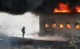 Man, Standing Next To Burning Building